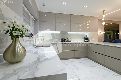 Image of closeup to white modern marble kitchen furniture in studio space