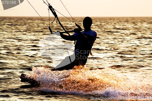 Image of Silhouette of a kitesurfer on a waves