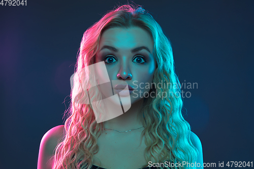 Image of Caucasian young woman\'s portrait on gradient background in neon light