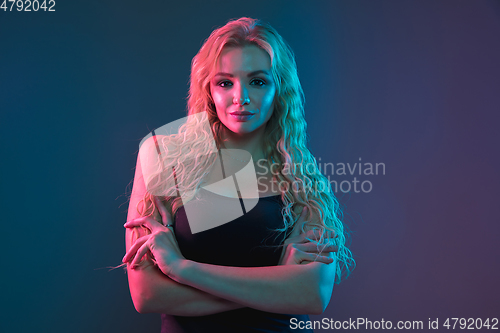 Image of Caucasian young woman\'s portrait on gradient background in neon light