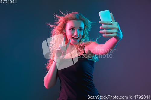 Image of Caucasian young woman\'s portrait on gradient background in neon light