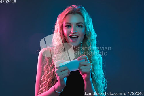 Image of Caucasian young woman\'s portrait on gradient background in neon light