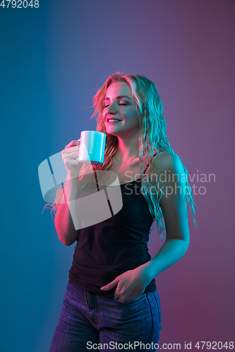 Image of Caucasian young woman\'s portrait on gradient background in neon light