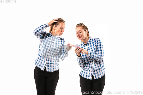 Image of Young handsome woman arguing with herself on white studio background.