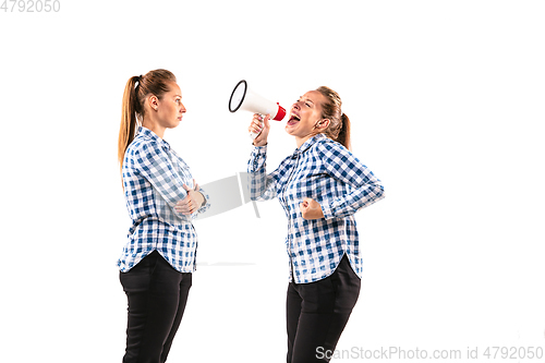 Image of Young handsome woman arguing with herself on white studio background.