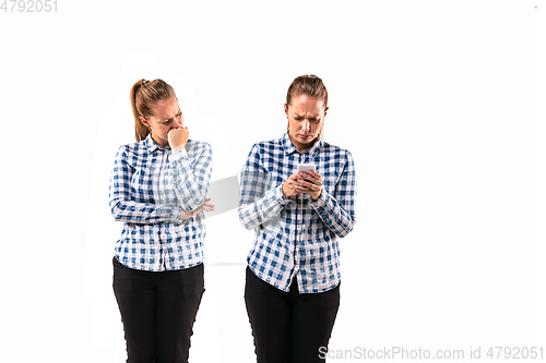 Image of Young handsome woman arguing with herself on white studio background.