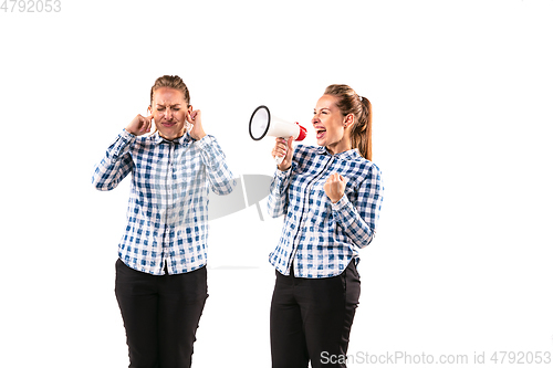 Image of Young handsome woman arguing with herself on white studio background.