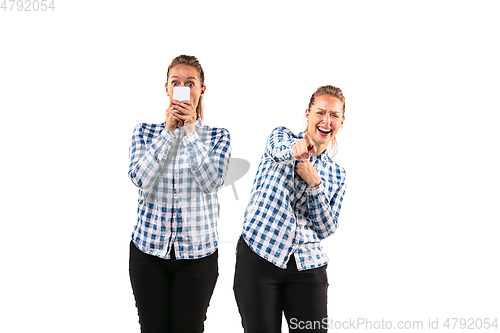 Image of Young handsome woman arguing with herself on white studio background.