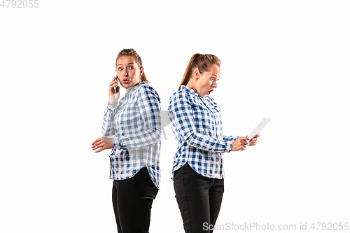 Image of Young handsome woman arguing with herself on white studio background.