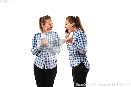 Image of Young handsome woman arguing with herself on white studio background.