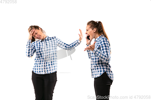 Image of Young handsome woman arguing with herself on white studio background.