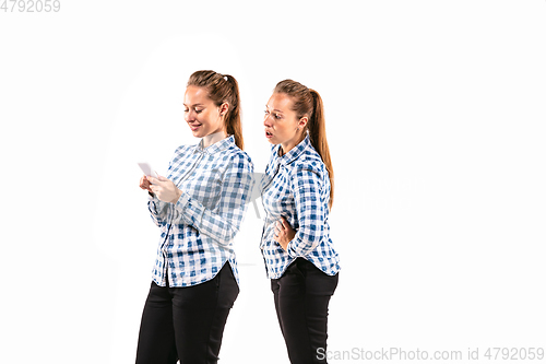 Image of Young handsome woman arguing with herself on white studio background.