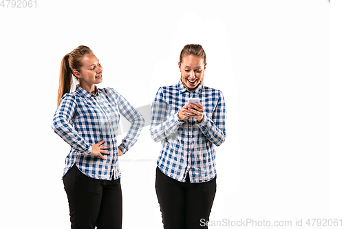 Image of Young handsome woman arguing with herself on white studio background.