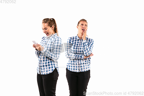 Image of Young handsome woman arguing with herself on white studio background.