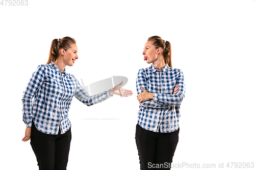 Image of Young handsome woman arguing with herself on white studio background.