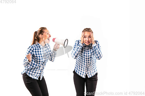 Image of Young handsome woman arguing with herself on white studio background.