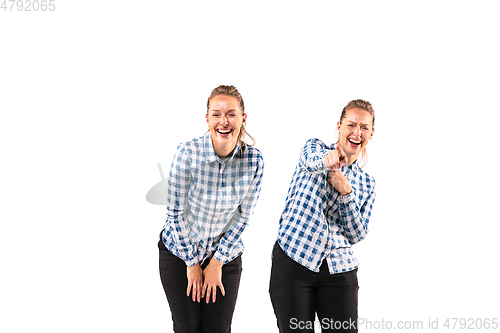 Image of Young handsome woman arguing with herself on white studio background.