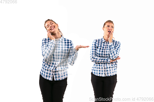 Image of Young handsome woman arguing with herself on white studio background.