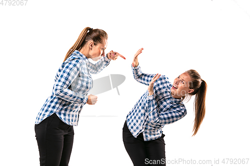 Image of Young handsome woman arguing with herself on white studio background.