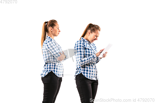 Image of Young handsome woman arguing with herself on white studio background.