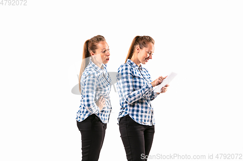 Image of Young handsome woman arguing with herself on white studio background.