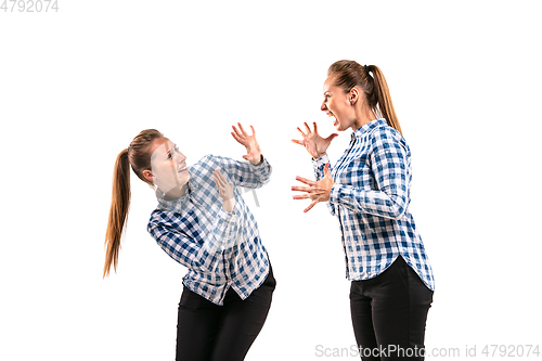 Image of Young handsome woman arguing with herself on white studio background.