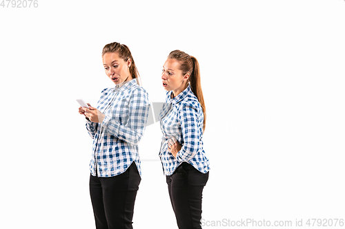 Image of Young handsome woman arguing with herself on white studio background.