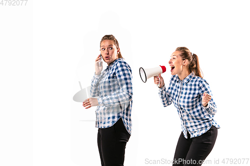 Image of Young handsome woman arguing with herself on white studio background.