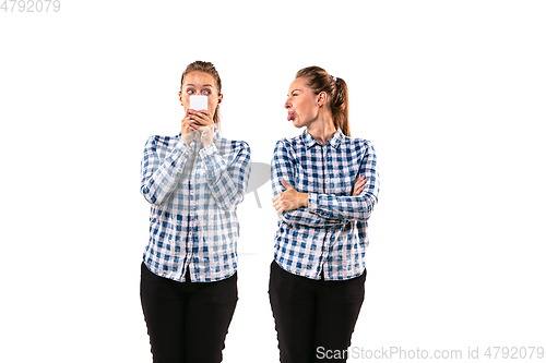 Image of Young handsome woman arguing with herself on white studio background.