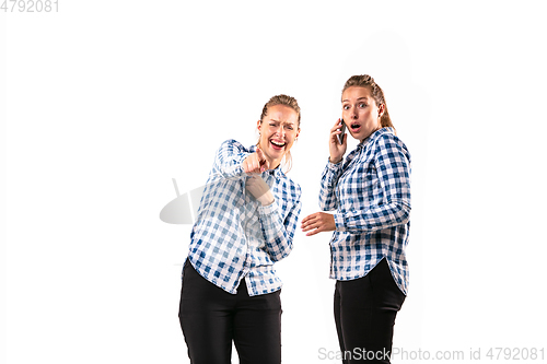 Image of Young handsome woman arguing with herself on white studio background.