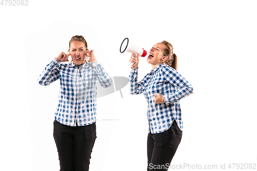 Image of Young handsome woman arguing with herself on white studio background.