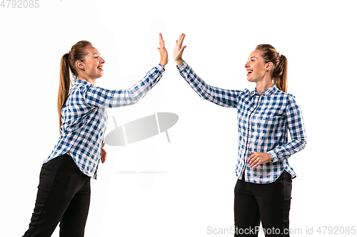 Image of Young handsome woman arguing with herself on white studio background.