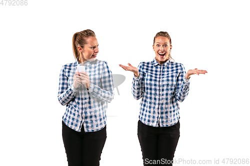 Image of Young handsome woman arguing with herself on white studio background.