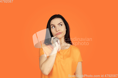Image of Caucasian young woman\'s portrait on orange background