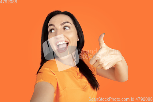 Image of Caucasian young woman\'s portrait on orange background