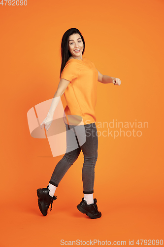 Image of Caucasian young woman\'s portrait on orange background