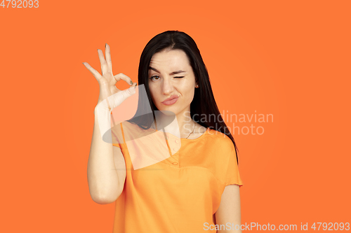 Image of Caucasian young woman\'s portrait on orange background