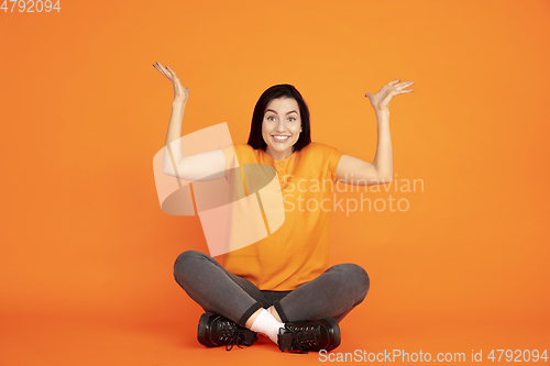 Image of Caucasian young woman\'s portrait on orange background
