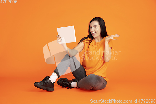 Image of Caucasian young woman\'s portrait on orange background