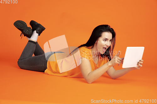 Image of Caucasian young woman\'s portrait on orange background