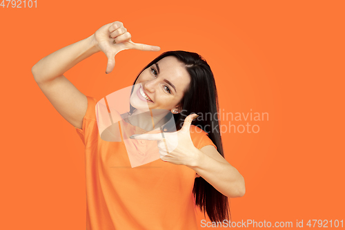 Image of Caucasian young woman\'s portrait on orange background