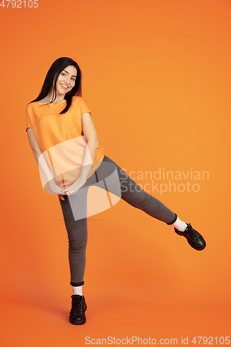 Image of Caucasian young woman\'s portrait on orange background