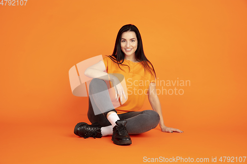 Image of Caucasian young woman\'s portrait on orange background