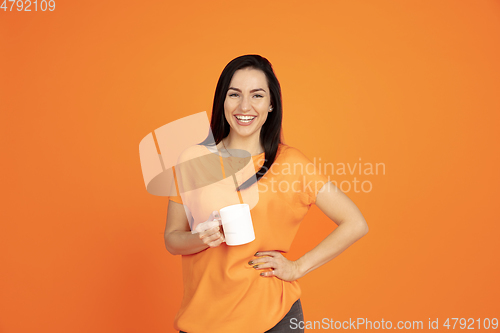 Image of Caucasian young woman\'s portrait on orange background