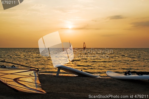 Image of Silhouette of a two windsurfer on a gulf on a sunset