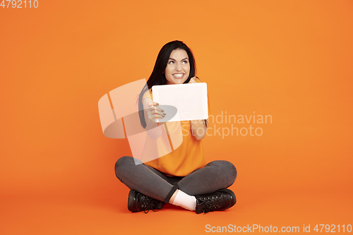 Image of Caucasian young woman\'s portrait on orange background