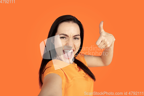 Image of Caucasian young woman\'s portrait on orange background