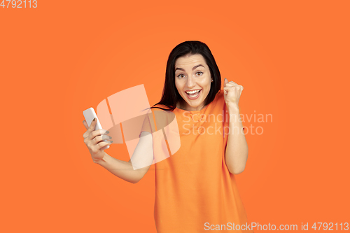 Image of Caucasian young woman\'s portrait on orange background