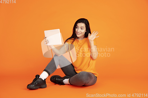 Image of Caucasian young woman\'s portrait on orange background