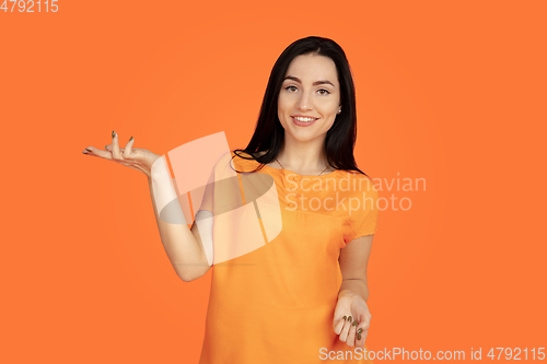 Image of Caucasian young woman\'s portrait on orange background